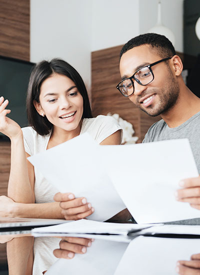 female on left and male on right look at papers will using the mortgage calculator